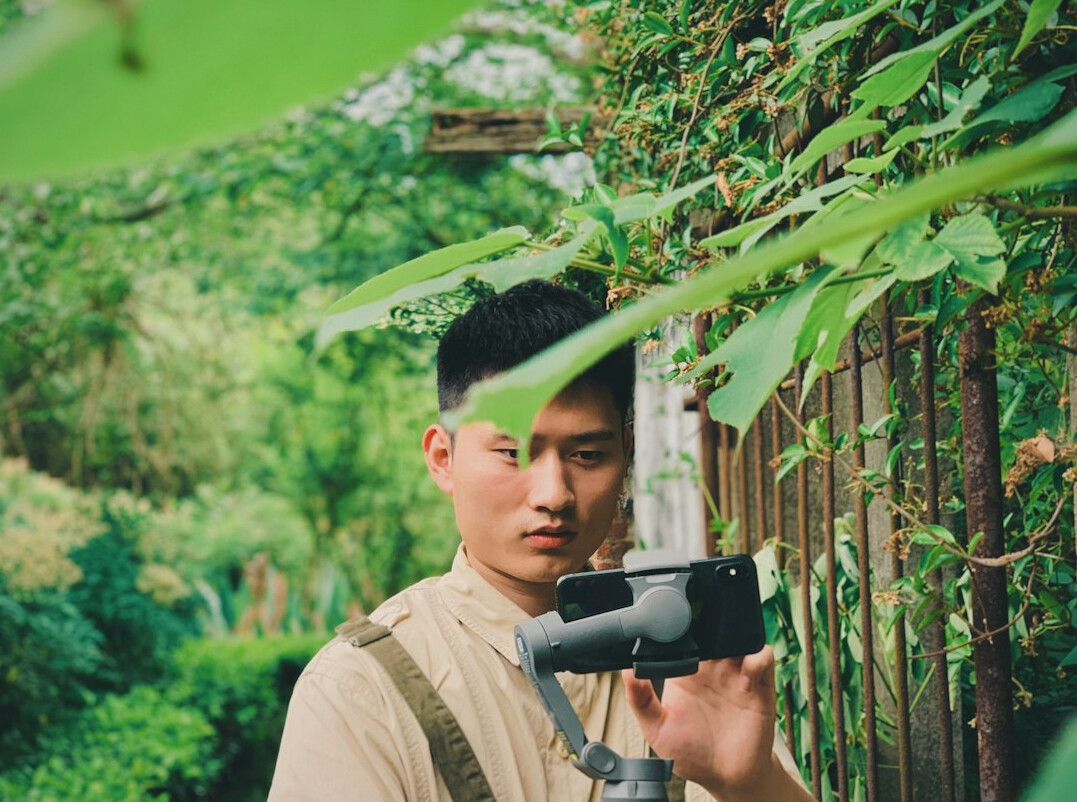 Young man operating a gimbal stabilizer while filming a scene