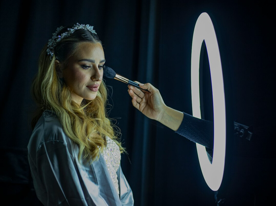 Young woman filming vertical video content with a smartphone on a ring light stand